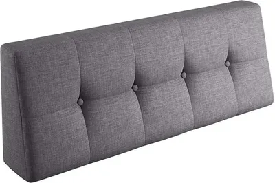 A gray upholstered headboard with button tufting.