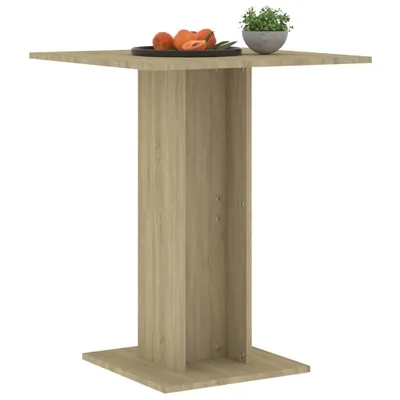 A square bistro table with a pedestal base, made of wood-look material, is shown against a white background. A small plate with fruit and a potted plant are on the tabletop.