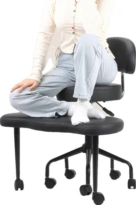 A person is sitting on a black ergonomic chair.