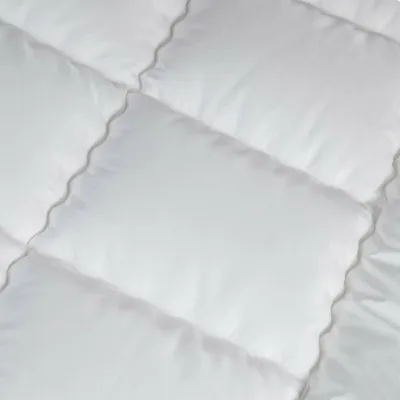 A close-up view of a white quilted blanket or comforter.