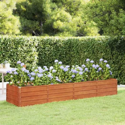 A raised garden bed filled with hydrangeas sits on a green lawn, with a hedge and trees in the background.