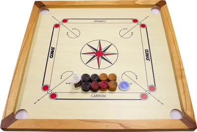 A carrom board game with its accessories laid out on the playing surface.