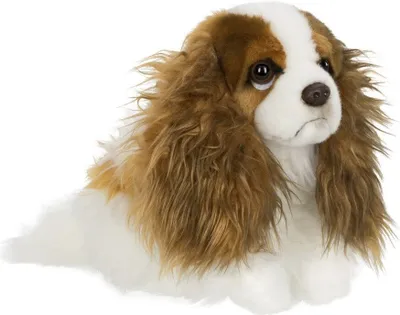 A plush toy dog is lying down on a white background.