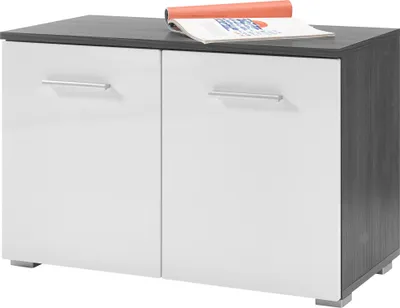 A two-door cabinet with a dark gray top and sides, and white doors with silver handles. A rolled-up magazine or brochure is placed on top of the cabinet.