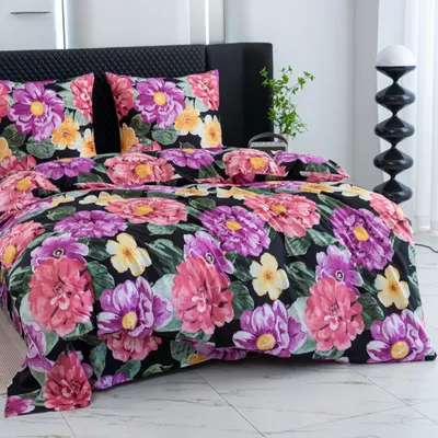 A close-up view of a bed with a floral-patterned duvet and pillows.