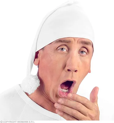 A man wearing a white nightcap and shirt is yawning.