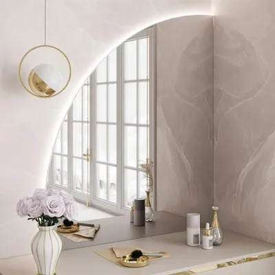 A vanity table with a mirror, flowers, and makeup products.