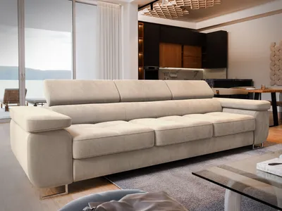 A modern living room with a large sofa, a coffee table, and a kitchen area in the background.