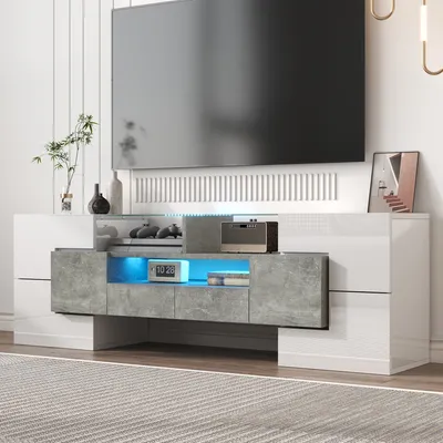 A modern TV stand with LED lighting, displaying electronic devices and decorative items.