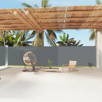 An outdoor patio area with a retractable side awning, a hanging chair, and a small table with chairs.