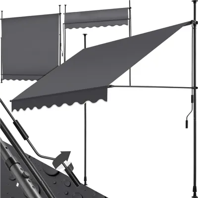 A dark gray retractable awning is shown in a studio setting against a white background. The awning is partially extended, and its frame and crank mechanism are visible. There are also two other awnings in the background, one fully retracted and one partial