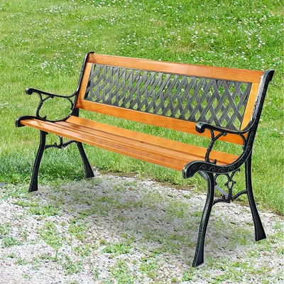 A park bench made of wood and cast iron is shown outdoors on a gravel path with grass in the background.