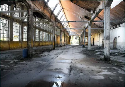 Produktbild von Wallario Fototapete Vliestapete, seidenmatte Oberfläche, einfache Verarbeitung, Größe 400 x 280 cm, Motiv Alte Industriehalle  leerstehend und einsam