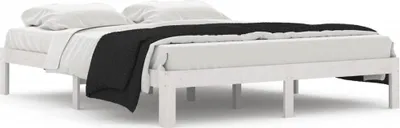 A white wooden bed frame with white bedding and a black throw blanket.