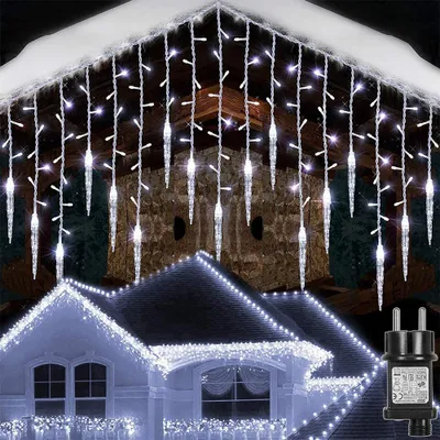 Icicle lights are decorating the roofline of a house at night.