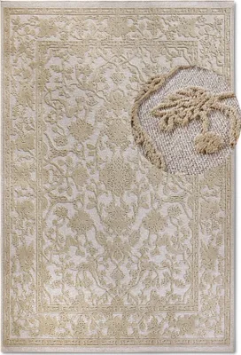 A close-up view of a cream-colored rug with an intricate floral pattern.