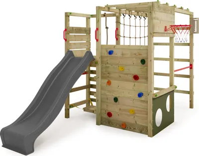 A wooden playground structure with a slide, climbing wall, rope net, and basketball hoop, set against a white background.