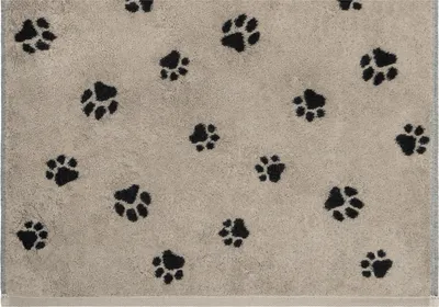 A close-up view of a beige towel with a pattern of black paw prints.