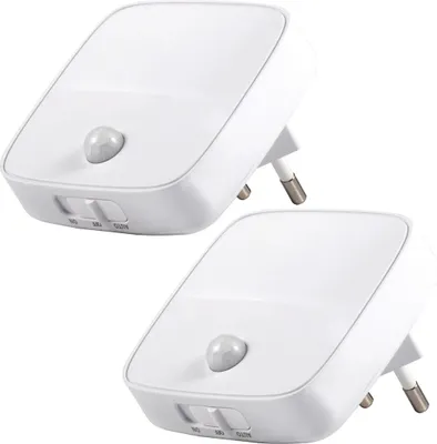 Two white LED night lights with motion sensors plugged into an outlet.