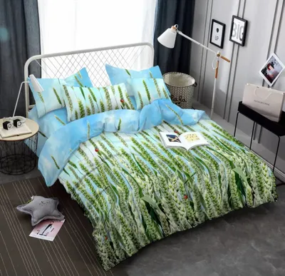 A bedroom scene with a bed made up with a nature-themed duvet cover.
