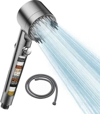A silver shower head with water spraying out, and a coiled gray hose next to it. The shower head has a transparent section showing layers of filter material.