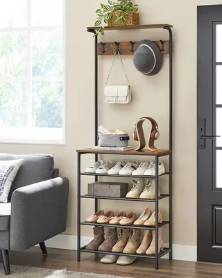 A hallway storage unit with shelves and hooks for coats, hats, bags, and shoes, placed near a window and a sofa.