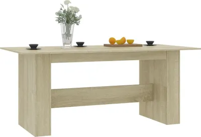 A light brown wooden dining table with a vase of flowers and fruit on top, set against a white background.