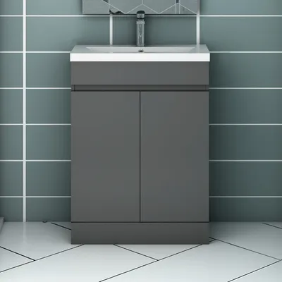 A bathroom vanity with a sink and faucet, set against a tiled wall and floor.
