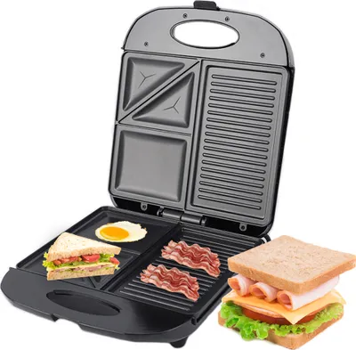 A sandwich maker with various food items like a sandwich, egg, and bacon on its plates, and a finished sandwich next to it.