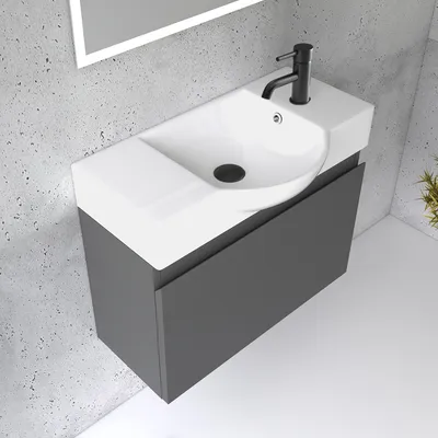 A modern bathroom vanity with a sink and faucet against a concrete wall.