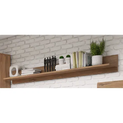 A wooden shelf mounted on a white brick wall, displaying books and decorative items.