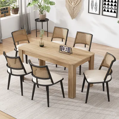 A dining room scene with a wooden table and six rattan chairs.