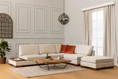 A modern living room setting with a sectional sofa, coffee table, and ottoman.