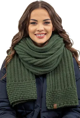 A woman wearing a green scarf and a dark blue jacket.