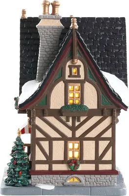 A miniature Christmas village house with a decorated Christmas tree.
