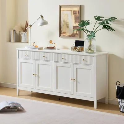 A white sideboard with four doors and two drawers is displayed in a well-lit room, with decorative items on top.