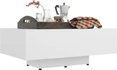A white coffee table with decorative items on top.