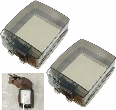Two transparent gray outlet covers are shown from a top-down perspective, with a smaller inset image showing one cover installed on a wall outlet.