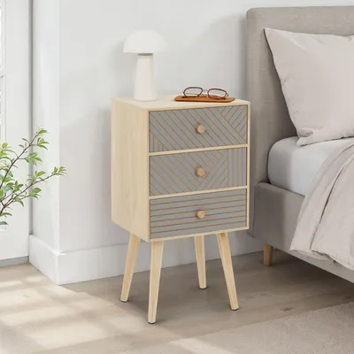 A bedside table next to a bed in a bedroom.