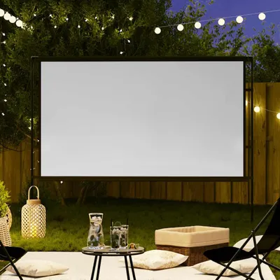 An outdoor movie setup at night with a projector screen, string lights, and seating.