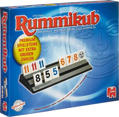 The image shows the front of a Rummikub game box, with some of the game tiles and racks visible.