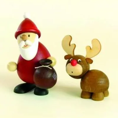 A wooden Santa Claus figurine holding a gift bag next to a wooden reindeer figurine.