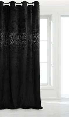 A black velvet curtain with sparkling details is shown hanging in front of a window.