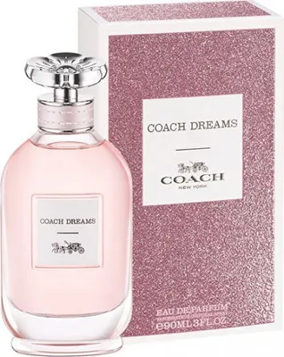 A bottle of Coach Dreams Eau de Parfum and its packaging are displayed against a white background.