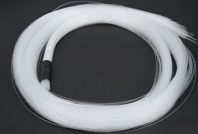 A coiled bundle of white fiber optic cables on a black background.