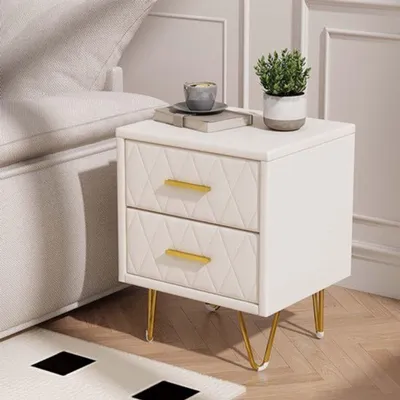 Immagine prodotto di Comodino beige con dettagli dorati, dotato di gambe in legno e metallo e due ampi cassetti