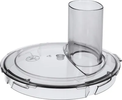 A clear, professional studio shot of a clear plastic food processor lid with a feeding chute.