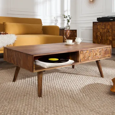 A living room scene featuring a wooden coffee table with a vinyl record and a teacup on it, a yellow sofa, and a wooden cabinet.