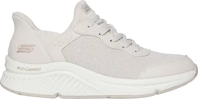 A side view of a beige Skechers sneaker.