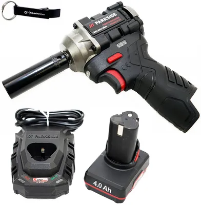 A product shot of a cordless impact wrench kit, including the tool, battery, charger, and a keychain, against a white background.